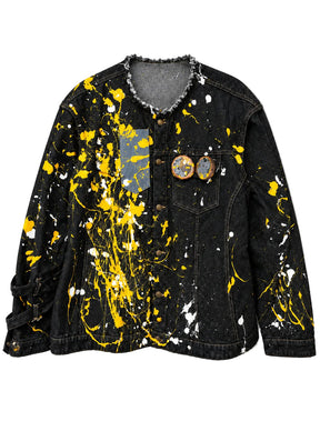"Urban Ghost" Denim Jacket in black denim with yellow and white paint splatters, distressed raw-edge collar and two portrait pins on chest.